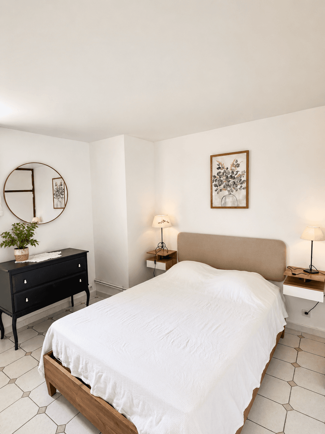 Chambre des Citronniers, avec lit double, commode noire et miroir rond.